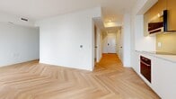 Located at 11 Duncan Street in the heart of Toronto's Financial District, this modern 3-bedroom, 1-bathroom unit showcases a clean and contemporary design throughout. Signature light oak herringbone hardwood flooring runs continuously across the entire floor plan, lending a sophisticated and cohesive aesthetic to every room.

A bright, well-proportioned hallway connects the bedrooms, each featuring floor-to-ceiling sliding closets with glossy white panel doors and large windows that frame sweeping views of the Toronto skyline. Architectural cylindrical columns add a distinctive design element in select rooms, complementing the crisp white walls and minimalist trim details.

The bathroom is thoughtfully finished with soft aqua vertical subway tile surrounding a full soaking tub and shower combination, contrasted by a sleek dark floating vanity with an undermount sink and matte black fixtures — offering a refined, spa-like atmosphere.

The open living area benefits from abundant natural light through expansive windows, creating an airy ambiance that extends throughout the unit. Black hardware accents on doors provide a subtle contrast to the otherwise all-white interior palette. This unit offers a polished, move-in-ready space in one of Toronto's most central and accessible downtown locations.