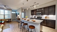 Located at 907 South Rd in Baytown, TX, this well-appointed single-story residence offers a thoughtfully designed layout with modern finishes and a warm, welcoming ambiance. The entryway sets an inviting tone with light wood-look flooring, a transom-lit front door, and tasteful décor accents.

The open-concept kitchen is a standout feature, showcasing rich dark espresso cabinetry, a classic white subway tile backsplash, stainless steel appliances, and a generously sized granite-topped island with bar seating — ideal for casual dining and entertaining. Track and pendant lighting illuminate the space with a contemporary flair.

The living area is bright and comfortable, benefiting from large windows dressed with sheer curtains that allow ample natural light and garden views. Light wood-look flooring continues throughout the main living spaces, complementing the neutral color palette.

The primary bedroom is a serene retreat, featuring plush carpet, multiple windows with outdoor views, and a ceiling fan. Its en-suite bathroom offers a dual-sink granite vanity with dark cabinetry and leads to a spacious walk-in closet. A secondary bedroom provides equal comfort with natural light and soft carpet. The second bathroom includes a soaking tub, tiled surround, and granite vanity. A dedicated laundry room with full-size washer and dryer connections completes this well-rounded residence.