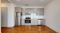 Located at 26800 N 27th Ave in Phoenix, AZ, this one-bedroom, one-bathroom unit offers a thoughtfully designed layout that maximizes every square foot of its compact footprint. Warm wood-look flooring runs consistently throughout the entire space, creating a cohesive and inviting atmosphere from room to room.

The kitchen is a standout feature, outfitted with a full suite of stainless steel appliances — including a refrigerator, electric range, built-in microwave, and dishwasher — complemented by sleek gray cabinetry, light stone countertops, and a classic white subway tile backsplash. The open design allows the kitchen to flow naturally into the living area, which is bright and airy, featuring large vertical blinds that filter natural light.

The bedroom is a well-proportioned, private retreat complete with a ceiling fan and clean white walls. A hallway connects the main living spaces and includes a programmable thermostat, with panel-style doors adding a modern touch. The bathroom features gray cabinetry with ample drawer storage, a stone-topped vanity with an undermount sink, a large mirror, and a walk-in shower with glass enclosure. The overall aesthetic is modern and minimalist, ideal for comfortable urban living in North Phoenix.