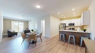 Located at 60 Maple St in Branford, Connecticut, this thoughtfully designed two-bedroom, two-bathroom residence offers a comfortable and modern single-floor layout. The open-concept living and dining area flows seamlessly into the kitchen, all finished with light-toned hardwood-style flooring that unifies the space. Recessed lighting and a wall-mounted mini-split system are featured throughout, ensuring year-round comfort. The kitchen is a standout, featuring white shaker cabinetry, stainless steel appliances including a full-size refrigerator, microwave, and range, as well as a peninsula with a white quartz countertop and seating for multiple bar stools — ideal for casual dining or entertaining. The living room receives natural light through a large sliding door, offering views of the surrounding area. Both bedrooms are well-proportioned and serene, with the secondary bedroom boasting a window framing picturesque marina views. A dedicated closet provides practical storage. The two bathrooms are cleanly finished, with one featuring a walk-in glass-enclosed shower, warm wood vanity cabinetry, and white countertops. The overall aesthetic is clean, contemporary, and inviting throughout.
