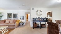 This single-floor, 2-bedroom, 1-bathroom home offers a thoughtfully organized layout that maximizes comfort and functionality. The combined living and dining area serves as the heart of the home, where an eye-catching exposed brick accent wall in the living room provides a warm, textured focal point flanked by natural light from multiple windows with blinds and drapery. The open flow between the living and dining spaces makes the floor plan feel expansive and welcoming.

The dining area features a large window that fills the room with natural light, creating a bright and inviting atmosphere for meals. Adjacent to the dining space, a dedicated sideboard area adds practical serving and storage capability. The kitchen is equipped with dark wood cabinetry, granite-toned countertops, a stainless steel sink, dishwasher, and a pantry for additional storage.

The primary bedroom is a comfortable and well-proportioned retreat, featuring carpeted flooring, a window with natural light, and closet access. The second bedroom offers similar comfort. The full bathroom includes a tub-shower combination with white tile surround, wood-style flooring, a vanity with granite-toned countertop, and ample storage. Three closets throughout the home ensure generous storage options.