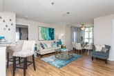 This thoughtfully designed two-bedroom home offers a seamless single-level layout that balances comfort and functionality. The open-concept living and dining area is anchored by warm hardwood-style flooring, allowing natural light to flow throughout the space. A ceiling fan overhead and a welcoming entryway add to the airy feel, while the combined living and dining zones provide ample room for both relaxing and entertaining.

The galley-style kitchen is efficiently organized with white cabinetry, granite-style countertops, stainless steel appliances including a refrigerator and microwave, and a gas range. A breakfast bar offers casual seating and connects the kitchen to the main living space.

Both bedrooms feature plush carpeting, ceiling fans, and generous windows that invite natural light. The primary bedroom includes a walk-in closet with built-in shelving for organized storage, while the second bedroom also offers closet access. Each room provides a calm, comfortable retreat.

The full bathroom is finished with a granite-style vanity, white cabinetry, a large mirror with overhead lighting, and a soaking tub with shower. Hardwood-style flooring extends into the bathroom for a cohesive look.

A dedicated laundry area with an in-unit washer and overhead shelving rounds out the practical features of this well-equipped home.