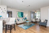 This thoughtfully designed two-bedroom home offers a seamless single-level layout that balances comfort and functionality. The open-concept living and dining area is anchored by warm hardwood-style flooring, allowing natural light to flow throughout the space. A ceiling fan overhead and a welcoming entryway add to the airy feel, while the combined living and dining zones provide ample room for both relaxing and entertaining.

The galley-style kitchen is efficiently organized with white cabinetry, granite-style countertops, stainless steel appliances including a refrigerator and microwave, and a gas range. A breakfast bar offers casual seating and connects the kitchen to the main living space.

Both bedrooms feature plush carpeting, ceiling fans, and generous windows that invite natural light. The primary bedroom includes a walk-in closet with built-in shelving for organized storage, while the second bedroom also offers closet access. Each room provides a calm, comfortable retreat.

The full bathroom is finished with a granite-style vanity, white cabinetry, a large mirror with overhead lighting, and a soaking tub with shower. Hardwood-style flooring extends into the bathroom for a cohesive look.

A dedicated laundry area with an in-unit washer and overhead shelving rounds out the practical features of this well-equipped home.