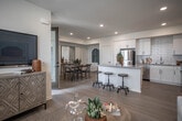 Located at 9174 Indiana Ave in Riverside, California, this single-story residence offers a thoughtfully designed open-concept floor plan that seamlessly connects the kitchen, dining, and living areas. The kitchen is a standout feature, showcasing crisp white shaker cabinetry, a classic subway tile backsplash, light quartz countertops, and a full suite of stainless steel appliances including a gas range, dishwasher, microwave, and refrigerator. Light wood-style flooring flows throughout the main living areas, creating a cohesive and airy feel. The dining area accommodates a full-sized table and benefits from natural light streaming through large windows dressed with plantation shutters. The living room is bright and inviting, with a ceiling fan, generous windows, and direct access to an outdoor area via glass doors. The space includes multiple bedrooms, each carpeted for comfort and outfitted with ample natural light. The primary bathroom features a dual-sink vanity with white cabinetry and a walk-in shower, while a secondary bathroom offers a full tub-shower combination. Recessed lighting throughout, neutral tones, and clean architectural lines give this residence a modern yet welcoming ambiance.