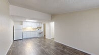 Located at 1969 Crystal Grove Ln in Lakeland, FL, this single-floor, one-bedroom, one-bathroom unit offers a practical and functional layout. Wood-style plank flooring runs throughout the entire space, providing a cohesive look and easy maintenance. The open living area is bright and welcoming, featuring a wall-mounted HVAC unit and a large window with vertical blinds that allows natural light to fill the room. The kitchen flows directly from the living space and is outfitted with white cabinetry, light granite-style countertops, a white range, and a built-in skylight above that adds additional brightness. A hallway connects the main living area to the private bedroom, which includes a ceiling fan with light fixture, a window with natural views, and a double-door closet offering generous storage. An additional closet is accessible off the hallway. The full bathroom features a combined tub-shower unit, toilet, and a white vanity. A dedicated laundry room houses the water heater and provides space for a washer and dryer hookup. Textured ceilings and clean white trim are consistent throughout, contributing to a neat, uniform aesthetic across the entire unit.