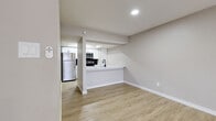 This thoughtfully renovated single-floor unit showcases a clean, contemporary design with a neutral color palette and luxury vinyl plank flooring that flows seamlessly throughout every room. The open-concept living and dining area offers a generous, airy feel, anchored by a ceiling fan and sliding glass door that invites natural light from outside. A peninsula-style kitchen connects directly to the living space, featuring white shaker cabinetry with matte black hardware, quartz countertops, a black pull-down faucet, and a full suite of stainless steel appliances including an electric range, over-the-range microwave, dishwasher, and refrigerator. A striking hexagonal tile backsplash adds a modern accent to the cooking area. The bedrooms are well-proportioned, each equipped with ceiling fans and ample closet space, including double sliding-door closets in the primary bedroom. The bathrooms are finished to a high standard — one features a tub-shower surround clad in marble-look tile with matte black fixtures, while the other offers a bright vanity with a wide mirror and contemporary lighting. Clean white cabinetry and consistent matte black hardware tie the bathrooms together cohesively. The overall design is modern, functional, and move-in ready.