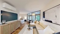 Located at 100 Reserve Road, unit M-12 is a thoughtfully designed one-bedroom, one-bathroom residence that makes excellent use of its efficiently organized single-floor layout. Warm hardwood flooring flows throughout, unifying every room with a cohesive, modern aesthetic.

The open-concept kitchen and living area forms the heart of the home. The kitchen features dark cabinetry with brushed hardware, white quartz countertops, a subway tile backsplash, and a stainless steel sink — providing a sleek, functional workspace. The living area is generously proportioned, anchored by a large sectional sofa and framed by a wall of floor-to-ceiling windows that flood the space with natural light and offer tranquil views of mature trees outside.

The bedroom is a calm, neutral retreat with soft tones, warm lighting, and tasteful wall art. Adjacent to it is a walk-in closet outfitted with wire shelving systems for versatile storage. The bathroom features white cabinetry, a wide vanity mirror, and matching hardwood-style flooring for a clean, cohesive finish.

A dedicated in-unit laundry nook houses a full-size front-load washer, adding everyday convenience. A wall-mounted split HVAC system ensures year-round comfort. The overall ambiance is bright, serene, and modern throughout.