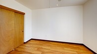 Located in Portland's vibrant Northwest neighborhood, this two-bedroom, one-bathroom residence offers a well-organized single-floor layout that maximizes every square foot of its compact footprint. Warm hardwood flooring runs throughout the main living areas and bedrooms, creating a cohesive and inviting atmosphere from the moment you enter.

The entrance leads into a combined living and dining area bathed in natural light through large windows dressed with vertical blinds. The galley-style kitchen features abundant white cabinetry with wood-trimmed detailing on both sides, providing generous storage and counter space, and is equipped with a range and refrigerator.

Both bedrooms are thoughtfully sized, with the primary bedroom offering comfortable accommodation. Each room benefits from hardwood floors, white walls, and windows that let in ample daylight. Two closets provide practical storage solutions throughout the unit.

The bathroom is clean and functional, featuring a full tub-shower combination with chrome grab bars and a classic white surround. Rich wood-toned door frames and dark baseboards offer a warm contrast to the bright white walls found throughout the space, lending the home a simple yet polished character suited to a range of personal styles.