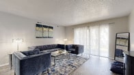 Located at 321 Imperial Blvd in Lakeland, FL, this single-floor, 2-bedroom, 1-bathroom residence offers a well-organized layout with wood-look flooring flowing through the main living areas. The living room is bright and welcoming, featuring large sliding glass doors with sheer curtains that invite abundant natural light and outdoor views. A textured ceiling adds character throughout the space. Adjacent to the living room, the dining area is illuminated by a pendant light fixture and opens seamlessly to the rest of the home. The kitchen is designed in a galley style, equipped with white cabinetry, granite-look countertops, a peninsula with bar seating, and black appliances including a range, dishwasher, and refrigerator. The primary bedroom is a comfortable retreat with plush carpeting, a ceiling fan, and soft neutral tones. The second bedroom also features carpet, a ceiling fan, and a bright window with outdoor views, and can serve flexibly as an office. The shared bathroom includes a white vanity, a tub-shower combination, and clean, neutral finishes. Two hallways connect the rooms efficiently, completing this practical and well-appointed Lakeland residence.