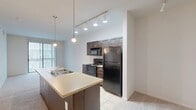 This 600 square foot apartment in Austin, Texas offers a thoughtfully designed living space perfect for modern urban dwellers. The single-level floor plan maximizes efficiency with one bedroom, one bathroom, and an open-concept living area. The primary bedroom, measuring 160 square feet, provides ample space and features a ceiling fan for comfort and a large window for natural light.

The kitchen stands out with its modern aesthetic, boasting dark wood cabinetry, black appliances, and a spacious island with a built-in sink. Pendant lighting adds a touch of sophistication, while the open layout seamlessly connects to the living area. Tile flooring in the kitchen transitions to plush carpeting in the living spaces, creating distinct zones within the open plan.

The bathroom showcases a contemporary design with a tiled floor, a vanity with storage, and a shower/tub combination adorned with decorative tile accents. A walk-in closet offers generous storage space with built-in shelving and hanging rods.

Throughout the apartment, recessed lighting and additional ceiling fans ensure bright, well-ventilated spaces. The neutral color palette and clean lines contribute to a fresh, modern ambiance. Located at 11400 Domain Dr., this apartment offers the perfect blend of style and functionality for those seeking a compact yet well-appointed living space in the heart of Austin.