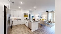 This well-appointed 2-bedroom, 2-bathroom residence in Centennial, CO offers a thoughtfully designed open-concept layout with modern finishes throughout. The kitchen is a standout feature, showcasing floor-to-ceiling white shaker cabinetry, a white subway tile backsplash, dark quartz countertops, and a full suite of stainless steel appliances including a French door refrigerator, range, microwave, and dishwasher. A peninsula with bar seating connects the kitchen seamlessly to the living area, making it ideal for both everyday living and entertaining. The living room is bright and welcoming, with large windows allowing ample natural light, wood-look plank flooring, and a ceiling fan overhead. Both bedrooms are comfortably sized, with the primary bedroom featuring a large window with outdoor views and dedicated closet space. The two bathrooms are clean and modern, with one featuring a soaking tub and shower combination with white tile surround and black fixtures. Additional highlights include an in-unit laundry area and two closets for generous storage. The consistent use of neutral tones, recessed lighting, and contemporary finishes gives the entire residence a cohesive, modern aesthetic.