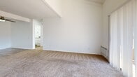 Located at 1942 Deerpark Dr in Fullerton, California, this single-floor 2-bedroom, 2-bathroom residence offers a thoughtfully laid-out living space with clean, bright interiors throughout. The open-concept kitchen and living area serves as the heart of the home, featuring white cabinetry, a peninsula breakfast bar with dark countertops, white appliances, recessed lighting, and wood-look vinyl flooring. A ceiling fan overhead enhances comfort in the adjoining living area. The living room is a standout, boasting soaring vaulted ceilings with exposed white beams and a sliding glass door that opens to a private patio, filling the space with natural light and outdoor views. Both bedrooms are carpeted and well-lit with windows overlooking the surroundings. The generously sized primary bedroom includes vaulted ceilings, a wall unit, and direct access to a full bathroom, along with a spacious walk-in closet outfitted with built-in shelving and hanging rods. The second bedroom also receives ample natural light. A hallway connects the bedrooms and bathrooms, which feature clean, bright tub/shower combinations. The consistent white palette and neutral carpet tones create a cohesive, move-in-ready ambiance throughout.