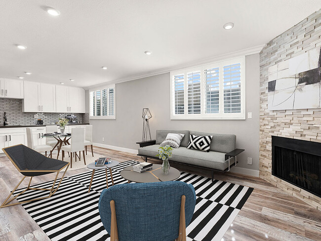 Hardwood floored living room with large windows and stone-accented fireplace. - Hi Point Townhomes