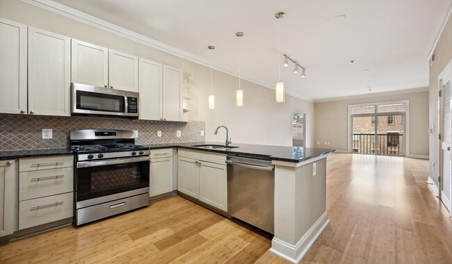 Stainless steel appliances and granite countertops in designer kitchen - Tremont Apartments