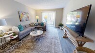 Located at 109 Pine Knoll Dr in Ridgeland, MS, this single-story, 2-bedroom, 2-bathroom home offers a thoughtfully arranged floor plan that maximizes every inch of its space. The open living and dining area serves as the heart of the home, featuring wood-style flooring, a textured ceiling, and a sliding glass door that fills the room with natural light and provides access to an outdoor balcony. The adjacent dining nook is defined by a bold teal accent wall, a pendant light fixture, and hardwood-style flooring, creating a warm and inviting atmosphere. The galley-style kitchen is well-appointed with rich dark cabinetry, granite-look countertops, stainless steel appliances, and hardwood-style flooring that ties the space together seamlessly. The primary bedroom is generously sized, featuring plush carpet, a ceiling fan with light fixture, and a window overlooking greenery. The second bedroom also offers comfortable carpet flooring and ample natural light. Both bathrooms are neatly finished — one featuring a vanity with granite countertops, dark wood cabinetry, and wood-style tile flooring, and the other a clean, functional shower/tub combo. Two closets provide practical storage throughout the home.
