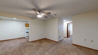 Located at 500 College Ave in Terre Haute, Indiana, this two-bedroom, one-bathroom unit offers a practical and comfortable single-floor layout. The living room serves as the central gathering space, featuring neutral carpet flooring, a ceiling fan with integrated lighting, and an open connection to the combined dining and kitchen area. The kitchen is laid out in a galley style, equipped with warm oak cabinetry on both sides, white appliances including a range and refrigerator, a double sink, light countertops, and wood-look vinyl flooring that adds warmth to the space. Both bedrooms are carpeted and feature textured ceilings, windows that bring in natural light, and warm wood-toned interior doors. The primary bedroom is generously sized and includes two closets, providing ample storage. The full bathroom includes a single-sink vanity with oak cabinetry, a tub-shower combination, and wood-look vinyl flooring consistent with the kitchen. Three closets are distributed throughout the unit, along with a dedicated utility room. Clean, neutral-toned walls and consistent wood trim detailing carry throughout the space, creating a cohesive and functional living environment.