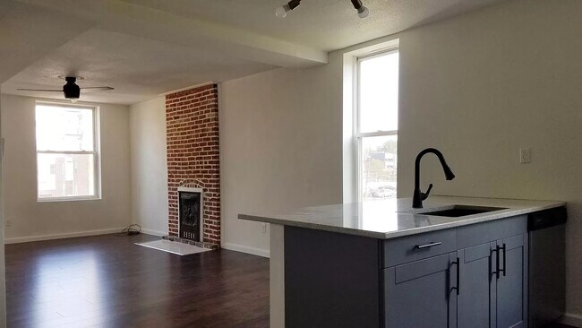 Gran salón con vistas a la cocina y a la chimenea antigua. - 4410 Swan Ave