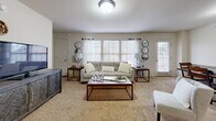 This 2-bedroom, 3-bathroom single-floor residence in Tulsa, Oklahoma offers a well-organized layout designed for comfortable everyday living. The open-concept living and dining area is carpeted and filled with natural light from multiple windows dressed with white blinds and sheer curtains. The space flows seamlessly into the kitchen, which is separated by a breakfast bar with seating. The kitchen is fully equipped with rich dark wood cabinetry, granite-style countertops, stainless steel appliances including a refrigerator, range, microwave, and dishwasher, and tile flooring. The primary bedroom is a well-proportioned retreat featuring plush carpet, a ceiling fan, a walk-in closet, and a private en-suite bathroom with a granite-topped vanity, dark wood cabinetry, and a tub-shower combo. The second bedroom is similarly appointed with carpet, a ceiling fan, and a window for natural light. Three bathrooms throughout the residence provide ample convenience. Two dedicated closets offer practical storage solutions. A connecting hallway ties the layout together efficiently. The neutral color palette, consistent use of dark wood accents, and tile flooring in wet areas contribute to a cohesive and functional aesthetic throughout.