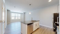 Located at 1271 Kelly Johnson Blvd in Colorado Springs, Colorado, this single-floor unit offers a thoughtfully designed open-concept layout that seamlessly connects the kitchen and living areas. Light-toned wood-style flooring runs throughout the main living spaces, contributing to a clean, contemporary aesthetic enhanced by neutral wall tones and crisp white trim.

The kitchen serves as the focal point of the main living area, anchored by a central island topped with richly veined granite countertops and fitted with an undermount sink and a brushed nickel faucet. A pendant light hangs above the island, adding a refined touch. White shaker-style cabinetry with sleek hardware lines the walls, complemented by a full suite of stainless steel appliances including a refrigerator, range, microwave, and dishwasher. Recessed lighting provides consistent illumination throughout the space.

The living area is generously proportioned, benefiting from a large window that draws in natural light and views of the surrounding neighborhood. The bedroom features plush carpeting, a ceiling fan, and direct access to a well-appointed bathroom area. A dedicated laundry space houses a stacked washer and dryer unit, adding everyday convenience to this well-finished Colorado Springs residence.
