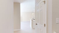 Located at 98 Waterside Drive in Wildwood, MO, this two-story, two-bedroom, two-bathroom unit offers a well-organized layout spread across two levels. The lower level houses an attached garage with an automatic opener and a utility room, providing practical storage and direct interior access. The main living level features an open-concept kitchen and living room filled with natural light. The living area includes a ceiling fan, a gas fireplace, and sliding glass doors that open onto a private balcony with outdoor views. The kitchen is appointed with white cabinetry, stainless steel appliances including a range, microwave, and refrigerator, and a peninsula with an integrated sink ideal for casual dining or meal prep. Neutral-toned walls and light flooring run throughout the main living areas, lending a clean and airy aesthetic. Both bedrooms are carpeted and include ceiling fans, with the primary bedroom offering a generous walk-in closet fitted with wire shelving. The two bathrooms are finished with white vanities, mirrors, and glass-enclosed shower stalls. A dedicated staircase connects the levels, and a separate closet provides additional storage. The overall design is practical, bright, and move-in ready.