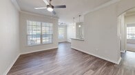 Located at 14695 Briar Forest Dr in Houston, TX, this single-story 2-bedroom, 2-bathroom home offers a thoughtfully designed layout with quality finishes throughout. The open-concept living room features wood-look flooring, crown molding, ceiling fan, and generous natural light streaming through wide windows with views of surrounding greenery. It flows seamlessly into the kitchen, which is equipped with rich dark cabinetry, granite countertops, stainless steel appliances including a refrigerator, range, microwave, and dishwasher, complemented by a subway tile backsplash and pendant lighting. Both bedrooms are carpeted and feature ceiling fans and well-sized windows that invite natural light. Each bedroom includes access to a closet, with the primary bedroom offering a notably spacious feel. The bathrooms are clean and modern, with one featuring a soaking tub and shower combination set in classic white subway tile alongside dark wood cabinetry. A dedicated laundry room houses a full-size washer and dryer with built-in shelving above. A patio extends the living space outdoors. With a hallway connecting all areas, this home balances practicality and comfort in a cohesive, well-finished package.