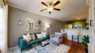 Located at 500 Trinity Ln N in Saint Petersburg, FL, this single-story, one-bedroom, one-bathroom residence offers a thoughtfully designed layout with a comfortable and functional flow. The open-concept kitchen and living room area serves as the heart of the home, featuring rich hardwood flooring, crown molding, and a ceiling fan. The kitchen is outfitted with white cabinetry, granite countertops, stainless steel appliances including a full-size refrigerator, microwave, and range, as well as a tile backsplash and a wine cooler — ideal for everyday cooking and entertaining. A curved granite-topped peninsula provides additional counter space and visual separation from the living area. The living room receives generous natural light through large windows with views of lush greenery, complemented by a built-in display cabinet and neutral, calming tones. The bedroom is a serene retreat with plush carpeting, a ceiling fan, and a large window that fills the room with natural light. A dedicated closet adds practical storage. The bathroom includes a combination tub and shower, a granite vanity, and hardwood flooring, maintaining the refined aesthetic found throughout the home. A hallway and entrance complete the well-organized floor plan of this inviting residence.
