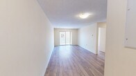 Located at Kipps Lane in London, Ontario, this well-appointed 3-bedroom, 2-bathroom unit offers a comfortable and functional layout across a single floor. Throughout the living areas and bedrooms, warm-toned hardwood-style flooring adds a clean, cohesive aesthetic, complemented by neutral cream-coloured walls and white baseboards that create a bright, inviting atmosphere.

The living room is generously sized, featuring a sliding glass door that opens onto a private balcony, where residents can enjoy open views of the surrounding neighbourhood. The kitchen is fitted with warm wood cabinetry, marble-patterned countertops, a tiled backsplash, and tile flooring, providing ample storage and counter space alongside a full electric range.

The three bedrooms are well-proportioned, each featuring the same hardwood-style flooring and neutral walls. The primary bedroom offers a comfortable footprint, while additional bedrooms provide flexible space for various needs. One bedroom benefits from a large window with treetop and skyline views, filling the room with natural light.

The two bathrooms serve the unit effectively — one features a clean stand-up shower stall, while the other includes a full tiled tub-and-shower combination with decorative tile accents and chrome fixtures. Textured ceilings are present throughout, adding a classic residential character to the space.
