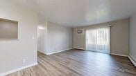 Located at 7191 Mentor Ave in Mentor, Ohio, this single-floor unit offers a clean, updated interior with a cohesive neutral color palette throughout. The open living area is a standout feature, showcasing light-toned luxury vinyl plank flooring, a textured ceiling, and a wall-mounted air conditioning unit. A full-width sliding glass door dressed with vertical blinds floods the space with natural light and provides direct outdoor access. Baseboard heating runs along the perimeter, offering efficient warmth throughout the living areas. The kitchen is well-appointed with white shaker-style cabinetry, granite-look countertops, a matte black faucet, and white appliances including a refrigerator and dishwasher, all set atop matching LVP flooring. The bedroom is carpeted with plush neutral-toned carpet, features two windows that bring in ample natural light, and is served by baseboard heating. The bathroom is finished in a clean, all-white palette with a full soaking tub and shower surround, a modern white vanity, and LVP flooring that ties seamlessly into the rest of the unit. The overall layout, as seen in the 3D floor plan, is functional and well-organized, making excellent use of the available space.