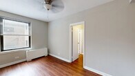 Located in Chicago, IL, this efficient one-bedroom, one-bathroom unit offers a well-organized layout across a single floor, making smart use of every square foot. Warm hardwood flooring flows consistently throughout the main living areas and bedroom, lending a cohesive and inviting character to the space.

The bedroom is cozy yet functional, featuring neutral gray walls, a ceiling fan with a light fixture, and a radiator along the wall for comfortable heating. Natural light filters in through windows fitted with horizontal blinds, and a doorway connects seamlessly to the hallway beyond.

The kitchen is compact and efficient, outfitted with rich, deep-toned cabinetry, granite-style countertops, a stainless steel sink, and a black range. A generous window brings in natural light, enhancing the warmth of the wood-toned cabinetry.

The bathroom is clean and well-appointed, featuring a white vanity with under-cabinet storage, a mirrored medicine cabinet with overhead lighting, and a full tub-shower combination. Two windows allow for natural light and ventilation.

A connecting hallway ties the rooms together, providing a logical and convenient flow throughout the unit. The consistent use of neutral tones, hardwood flooring, and clean white trim creates a unified, functional living environment well-suited for Chicago city life.