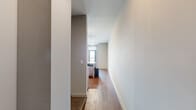 This well-appointed one-bedroom, one-bathroom residence in Memphis, Tennessee offers a thoughtfully designed single-level layout that maximizes functionality. The open-concept kitchen and living area serves as the heart of the unit, featuring warm hardwood-style flooring that runs throughout the main living spaces. The galley-style kitchen is outfitted with a full suite of stainless steel appliances — including an electric range, over-the-range microwave, refrigerator, and dishwasher — complemented by granite countertops and contemporary light wood cabinetry with modern hardware. Track lighting illuminates the kitchen, adding a sleek, modern touch. The living area offers a clean, neutral palette with crisp white walls and ample room to customize. A dedicated entry area benefits from a large window fitted with blinds, filling the space with natural light. The bedroom is a comfortable, private retreat featuring plush carpeting, a ceiling fan, and a sliding closet with built-in shelving. The full bathroom is finished with a granite-topped dark wood vanity, a large mirror, an overhead medicine cabinet, and a classic subway tile tub-shower surround. Throughout the unit, neutral gray and beige tones create a cohesive, modern aesthetic that is move-in ready.