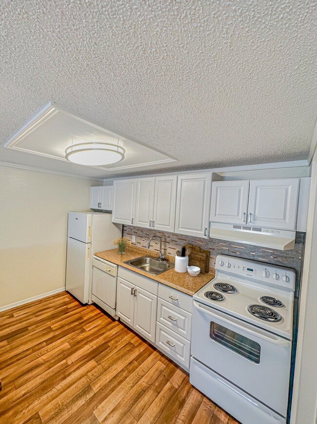Prepare comidas con facilidad en cocinas equipadas con electrodomésticos modernos, amplios gabinetes y diseños funcionales. - Beach Bluff Apartments