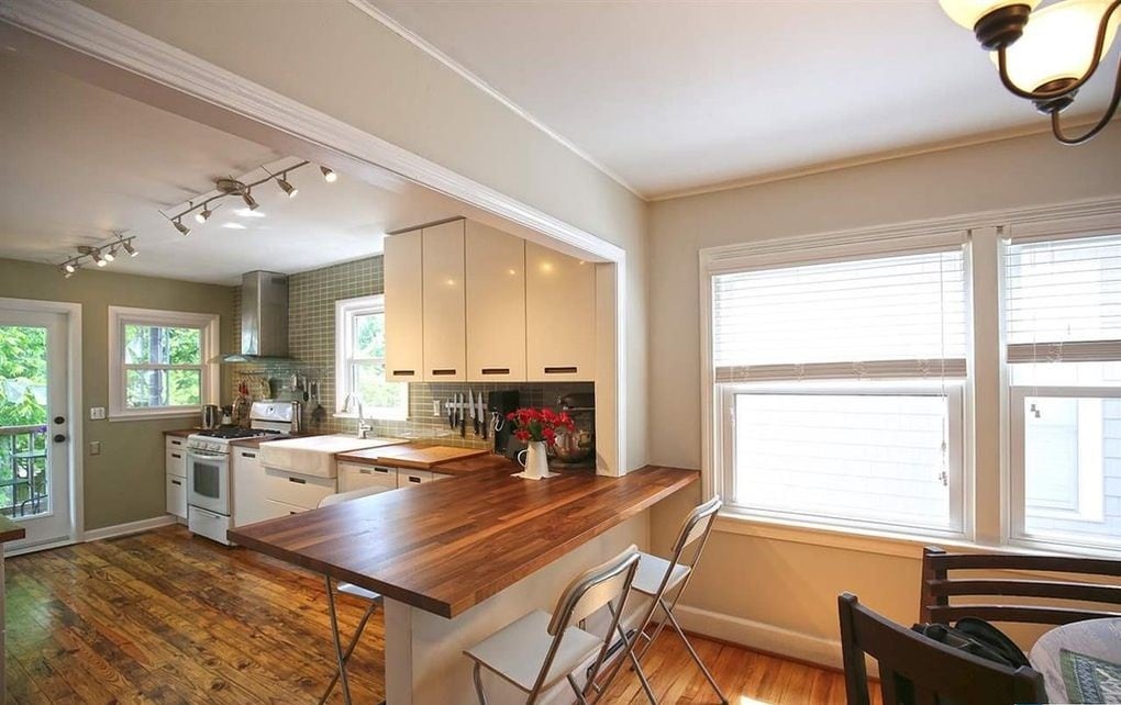 The kitchen has been lovingly updated with Maple countertops, a Breakfast Bar with seating for 4, a white Farm Sink, subway tile backsplash AND soft-close IKEA Cabinets - 903 Highland Rd