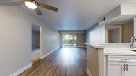 Located in Sherman Oaks, this thoughtfully designed 2-bedroom, 2-bathroom residence offers a comfortable and functional single-level layout. The open-concept living and kitchen area is anchored by warm wood-style flooring, a ceiling fan, and a large sliding glass door that floods the space with natural light and opens onto a private balcony overlooking a beautifully landscaped courtyard filled with mature palms and lush greenery. The kitchen features white cabinetry, a peninsula with a built-in sink, stainless steel appliances including a refrigerator and range, and a classic subway tile backsplash, all flowing seamlessly into the living area. Both bedrooms are carpeted and generously sized, with the primary bedroom offering ample closet space behind mirrored sliding doors. The two bathrooms are finished in a clean, modern style with light wood-tone flooring, white vanities, and glass-enclosed showers. Five closets throughout the unit provide abundant storage. With ceiling fans, updated finishes, and a serene balcony outlook, this residence balances everyday practicality with a relaxed Southern California ambiance.