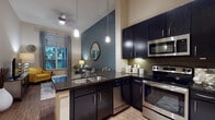 Located at 230 TC Jester Blvd in Houston, TX, this single-floor residence offers a cohesive and thoughtfully designed living environment. The open-concept kitchen is a standout, featuring dark espresso cabinetry, dark granite countertops, a tile backsplash, and a full suite of stainless steel appliances including a bottom-freezer refrigerator, electric range, built-in microwave, and dishwasher. Pendant lighting over the kitchen peninsula adds a refined touch, while wood-look flooring extends throughout the space.

The living area is warm and inviting, highlighted by a striking teal accent wall, soaring ceilings, and a large window that frames lush outdoor greenery and fills the room with natural light. A ceiling fan enhances comfort, and the open sightlines between the kitchen and living area create a sense of spaciousness.

The bedroom continues the teal accent wall motif, complemented by plush carpeting, large windows with outdoor views, and ample room for generous furnishings. The full bathroom is clean and functional, offering a tub-shower combination, dark vanity cabinetry, tile flooring, and additional overhead storage cabinetry — providing both style and practicality throughout.