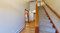 Located at 167–171 Windermere Ave in Ellington, Connecticut, this three-floor property offers a well-organized layout with functional spaces distributed across each level. The main living area features warm hardwood flooring, wood-trimmed windows that invite natural light, and a wood-mantled fireplace that serves as a focal point of the room. A peninsula counter connects the living space to the kitchen, which is equipped with warm oak cabinetry, recessed lighting, white appliances, and a double sink—offering a practical and cohesive workspace.

The entry level includes a carpeted staircase with a wood banister leading to the upper floor, alongside a closet and direct access to the kitchen. The upper level hosts generously sized rooms, including a spacious carpeted bedroom with multiple windows, a ceiling fan, and baseboard heating. A large walk-in closet with wire shelving provides ample storage. The bathroom features tile flooring, a white vanity with a large mirror, and baseboard heat. A dedicated laundry room with full-size washer and dryer hookups and overhead shelving adds convenience.

The lower level includes an attached garage with an epoxy-coated floor and an automatic door opener, as well as a utility basement housing the building's mechanical systems on a sealed concrete floor.