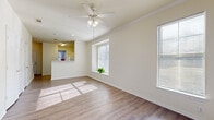 Located at 2631 John West Road in Dallas, TX, this two-story, two-bedroom, two-bathroom home offers a practical and well-designed layout spread across two evenly sized floors. The main level welcomes you through a dedicated entrance that opens into bright, open living and dining areas. Hardwood-style flooring flows throughout, complemented by neutral, light-toned walls that create a clean and airy atmosphere. Multiple windows flood the living spaces with natural light, while ceiling fans with integrated lighting add both comfort and function. The kitchen features white cabinetry extending to the ceiling, light granite-style countertops, a peninsula breakfast bar, and white appliances, offering ample storage and workspace. A staircase connects to the upper level, where both bedrooms are located, including a comfortable primary bedroom with a closet and vaulted ceiling detail. The second bedroom is bright with corner windows overlooking the neighborhood. The bathrooms are finished in white tile with a tub-shower combination and wood-style flooring. Additional highlights include multiple closets, a laundry area, and a hallway connecting the upper-floor rooms, making this a well-appointed and efficiently organized home.