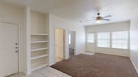 Located at 9257 Somerset Rd in San Antonio, TX, this two-story home offers a practical and comfortable layout spread across two levels. The main living area on the ground floor features warm neutral tones, plush carpeting, a ceiling fan, and built-in shelving — ideal for storage and display. Natural light filters in through blinded windows, creating a bright and welcoming atmosphere.

The kitchen is well-appointed with warm oak cabinetry, dark countertops, tile flooring, a double-basin sink, a dishwasher, an electric range, and a built-in microwave. A carpeted staircase connects the two floors, with the kitchen and main living spaces conveniently situated on the ground level.

The bedrooms are carpeted and generously sized, each equipped with ceiling fans. The primary bedroom features elevated ceilings and an en-suite bathroom with a wood-vanity, large mirror, and tile flooring. Additional bedrooms include double-door closets, offering ample storage. A secondary bathroom mirrors the same clean, functional design with a vanity, overhead mirror, wall-mounted cabinet, and tiled floors.

The home also includes an attached single-car garage with a roll-up door, providing secure parking and additional storage space. Throughout the home, the consistent use of neutral colors and durable materials creates a cohesive and move-in-ready environment.