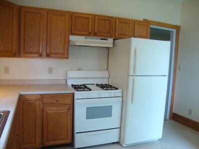 Cocina con estufa de gas y refrigerador. El fregadero está a la izquierda. - 512 S Center St