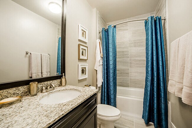 Baño con diseño de planta estilo mármol - Quarry at River North