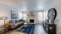 Located at 4035 Towne Crossing Blvd in Mesquite, TX, this one-bedroom, one-bathroom residence offers a practical and comfortable single-floor layout. The living room serves as the heart of the home, featuring wood-style flooring, a textured ceiling, and a classic white-trimmed fireplace flanked by windows that invite natural light. The open flow connects the living area to a dedicated dining space, both illuminated by ceiling fans and pendant lighting.

The galley-style kitchen is efficiently designed with dark cabinetry, white countertops, a double basin sink, and stainless steel appliances including a refrigerator, microwave, and dishwasher. A pass-through opening connects the kitchen to the dining area, enhancing the sense of openness. The kitchen also provides direct access to the in-unit laundry area.

The bedroom features plush carpeting, a ceiling fan, and ample natural light, offering a calm and comfortable retreat. An adjoining walk-in closet provides generous storage with multiple hanging rods and shelving. The bathroom includes dark cabinetry with brushed nickel hardware, a white countertop vanity, and a well-lit mirror. Wood-style flooring carries throughout the main areas, tying the space together cohesively.