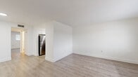 Located at 4810 E Busch Blvd in Tampa, Florida, this one-bedroom, one-bathroom unit offers a thoughtfully arranged single-floor layout with a clean, modern aesthetic throughout. Light wood-look flooring runs continuously across all rooms, complementing the crisp white walls and bright, neutral palette that define the space.

The living room provides a comfortable open area filled with natural light from a large window overlooking the exterior, with a welcoming entry door positioned nearby. The space flows naturally toward the kitchen, which is separated by a partial wall that adds a sense of definition without sacrificing openness. The kitchen is a standout feature, showcasing white shaker-style cabinetry, elegant marble-veined quartz countertops, a white tile backsplash, a stainless steel double-basin sink with a brushed nickel faucet, and stainless steel appliances including a full-size refrigerator and dishwasher.

The bedroom offers a comfortable footprint with a sliding-door closet providing practical built-in storage, a second closet accessible via a louvered door, and a window that brings in natural light. The bathroom is cleanly finished with a full tub-shower combination, white tile surround, and light wood-look flooring that maintains consistency with the rest of the unit. Overall, the space presents a fresh, move-in-ready environment with modern finishes throughout.