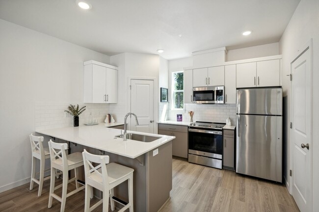 Tile backsplash, quartz counters, and abundant storage. - Holmes Park Townhomes