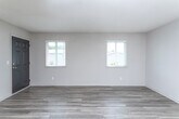 Located at 2540 Flat Shoals Rd in Decatur, Georgia, this single-story unit offers a well-organized layout that flows naturally from the living areas into the kitchen and bedrooms. The living room greets residents with wood-look laminate flooring, neutral-toned walls, and a textured ceiling, creating a clean, versatile backdrop. A sliding glass door fitted with vertical blinds opens to an outdoor area, allowing natural light to fill the space.

The kitchen is a functional highlight, featuring white shaker-style cabinetry, granite countertops, a white subway tile backsplash, and a full suite of stainless steel appliances including a range, dishwasher, and refrigerator. A pass-through counter connects the kitchen to the living area, enhancing the open feel.

The bedrooms are carpeted for comfort, with neutral walls and ample closet space—one bedroom notably includes two separate closets. Natural light enters through sizable windows fitted with blinds. Two bathrooms serve the unit: one includes a granite-topped vanity and a glass-enclosed shower, while the other features a tub-shower combination with brushed nickel fixtures, providing practical options for daily use.