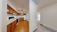 This single-floor unit at 1436 Lakeview Dr in Darien, IL offers a well-organized layout with clearly defined living, kitchen, and sleeping areas. The kitchen is a functional galley-style space featuring warm honey-toned wood cabinetry, light countertops, and hardwood flooring throughout. It is equipped with a range, dishwasher, refrigerator, and a double-basin sink, with ample upper and lower cabinet storage. A ceiling fan with a light fixture overhead provides both comfort and illumination. A pass-through opening connects the kitchen to the adjacent hallway, enhancing the sense of openness between spaces.

The living area is generously proportioned, finished with neutral-toned carpet and anchored by a large sliding glass door fitted with vertical blinds, allowing natural light to filter in and providing views of the surrounding greenery. A wall-mounted air conditioning unit and baseboard heating ensure year-round climate control.

The bedroom features carpet flooring, a window with vertical blinds overlooking the outdoors, and a spacious reach-in closet with bifold doors and built-in shelving. The bathroom includes a vanity with wood cabinetry, a mirror, and a full tub-shower combination with clean, neutral finishes.