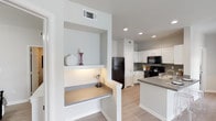Located at 5750 Curtis Clark Dr in Corpus Christi, TX, this single-floor residence offers a thoughtfully designed layout with a clean, contemporary aesthetic. Neutral gray walls, light wood-style flooring, and recessed lighting create a bright, cohesive atmosphere throughout.

The kitchen is a functional centerpiece, featuring white shaker cabinetry, gray countertops, a tile backsplash, and a full suite of black appliances including a gas range, microwave, refrigerator, and dishwasher. A peninsula provides additional prep and serving space, while a built-in nook with a small desk area adds a practical touch just off the kitchen.

The living area is open and inviting, with a large window allowing natural light to fill the room. Multiple bedrooms offer comfortable retreats; one features a ceiling fan and private exterior door access, while others showcase generous wall space and light-filtering windows. Each room maintains the home's consistent neutral palette.

The bathrooms are well-appointed with white cabinetry, gray countertops, and wood-style flooring. One bathroom includes a tub-shower combination, while another features a vanity with ample storage and an adjacent linen closet. The overall design of this residence balances practicality and modern style in a welcoming, move-in-ready package.