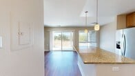 This 1,020-square-foot, single-story residence at Highlands of Marin in San Rafael, CA offers 3 bedrooms and 2 bathrooms across a well-planned open layout. Warm hardwood flooring flows consistently throughout every room, creating a cohesive and inviting ambiance.

The kitchen is a functional highlight, featuring granite countertops, a central island with pendant lighting, honey-toned wood cabinetry, a subway tile backsplash, and a full suite of stainless steel appliances including a gas range, microwave, dishwasher, and French door refrigerator. The adjacent living room benefits from abundant natural light via sliding glass doors that open to an outdoor view, and includes a classic fireplace with a white mantel as a focal point.

The primary bedroom spans 180 square feet with dual windows providing natural light and outdoor views. The two additional bedrooms are bright and well-sized, each featuring windows with views of surrounding greenery. All three bedrooms share access to a hallway connecting the full bathrooms, both of which feature granite-topped wood vanities, tub-shower combinations with white tile surrounds, and hardwood flooring.