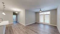 Located at 1330 Meeting St in Evansville, Indiana, this single-story, 3-bedroom, 2-bathroom home offers a clean, modern aesthetic throughout. The open living area is finished with light-toned hardwood-style flooring and neutral gray walls, creating a bright and welcoming atmosphere. A ceiling fan with a brushed metal finish anchors the main living space, which is flooded with natural light through a set of French doors fitted with white blinds. A chandelier adds a touch of elegance to the adjoining dining area. The kitchen is thoughtfully designed with white shaker-style cabinetry, white quartz countertops, a classic subway tile backsplash, and a full suite of stainless steel appliances, including a refrigerator, electric range, and over-the-range microwave. The hallway connects the living spaces to the three bedrooms, each carpeted in a neutral tone for comfort. The generously sized primary bedroom offers ample space and closet access. The two bathrooms feature white shaker vanities with quartz countertops and wood-look flooring. The primary bath includes a double-sink vanity with a large mirror and modern light bar, while the second bath provides a single-sink vanity with additional storage. A dedicated closet and hallway complete the practical layout of this well-finished home.