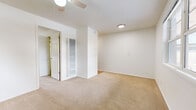 This well-organized one-bedroom, one-bathroom unit offers a practical and efficient layout across a single floor. The space is designed to maximize functionality, with each room serving a clear purpose.

The living area features neutral-toned wall-to-wall carpeting and a ceiling fan, creating a comfortable and understated atmosphere. Natural light filters in through a window, adding brightness to the room.

The bedroom is a well-proportioned private retreat, also finished with soft carpeting and equipped with a ceiling fan. A horizontal window allows natural light in while offering a view of the surrounding neighborhood. The room includes access to a dedicated closet with built-in shelving and a hanging rod, providing organized storage space.

The kitchen is compact yet fully equipped, featuring wood-accented cabinetry, upper and lower storage, a gas range, a refrigerator, and a double-basin sink set into granite-look countertops. Light hardwood-style flooring adds warmth to the space.

The bathroom is clean and straightforward, finished in white with a full-size soaking tub and shower combination, chrome fixtures, and hardwood-style flooring. The overall design of this unit is clean, minimal, and move-in ready, suited for those seeking a practical and easy-to-maintain living space.
