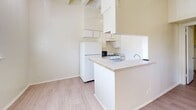 Located at 3107 Speedway Avenue in Austin's vibrant Hyde Park neighborhood, this one-bedroom, one-bathroom unit offers a thoughtfully designed layout across a single floor. The living area makes a strong first impression with its distinctive exposed beam ceiling, ceiling fan, and light wood-look flooring that runs throughout the space, creating a warm and cohesive aesthetic. Neutral cream-toned walls keep the interior bright and airy.

The kitchen is configured as a galley-style layout with a peninsula counter that opens toward the living area, providing an efficient and functional workspace. White cabinetry extends to the ceiling for generous storage, and the kitchen is equipped with a gas range, refrigerator, dishwasher, and a single-basin sink.

The bedroom features the same exposed beam ceiling detail and ceiling fan as the living area, along with a window that brings in natural light and a pleasant view of surrounding greenery. Built-in open shelving in the closet area provides convenient storage solutions.

The bathroom includes a full tub and shower combo with clean white tile surround. Throughout the unit, the consistent use of light tones, wood-look flooring, and architectural beam detailing lend a cohesive and functional character well-suited to the dynamic Austin lifestyle.
