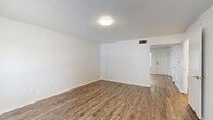 This two-story, three-bedroom, three-bathroom home in Jacksonville, Florida offers a practical and comfortable layout spread across two well-proportioned floors. The main level features a bright living room with wood-look flooring and a large window that brings in natural light and views of the surrounding neighborhood. The kitchen is well-appointed with rich, warm-toned cabinetry, light countertops, and white appliances including a dishwasher, range, and refrigerator, all set atop durable hardwood-style flooring. A dedicated laundry area and a hallway with closet space add to the home's functionality. The three bedrooms offer a comfortable retreat, with carpeted floors in the upper-level rooms providing a softer feel. The spacious primary bedroom includes a closet and windows that frame views of mature trees. Each of the three bathrooms features a full tub-shower combination with clean, white surrounds — one with wood-look flooring and warm-toned vanity countertops, another with tile flooring. Textured ceilings are consistent throughout the home, lending a classic residential character. The layout efficiently utilizes every level, making this a well-rounded home suited for a variety of living arrangements.
